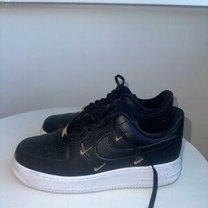 Nike Black Leather Low-Top Sneakers with Gold Swoosh Details
